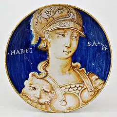 Plat peint en bicolore bleu et ocre à buste féminin orné d'une armure et d'un casque à plumes ; sur le fond bleu le mot « Marfisa » ; typologie des « Belles Femmes », Casteldurante, première moitié du XVIe siècle.