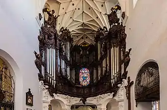 Photographie couleur d'un orgue en fer à cheval richement orné.