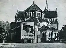 Photo ancienne représentant une cathédrale, à l'arrière de laquelle se trouve un portrait géant du maréchal Pétain.