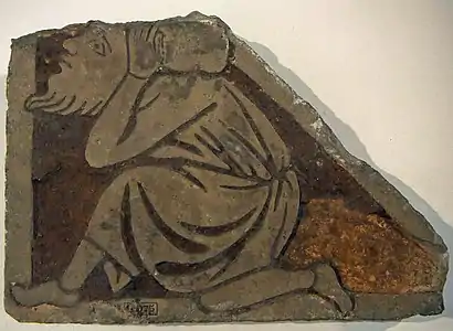 Carreau de pavement orné d'un homme genou à terre, provenant des fouilles de la cathédrale de Thérouanne par Camille Enlart. Château-musée de Boulogne-sur-Mer.