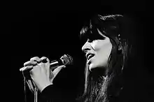 Une femme en noir et blanc chante.