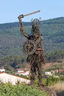 Photo en couleur d'une statue métallique ajourée représentant un guerrier viking casqué, brandissant un glaive
