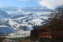 De hautes montagnes enneigées face au lampadaire d'un petit village.