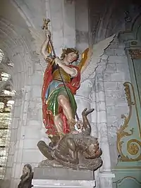 On voit une statue d'un ange qui repousse un démon grâce à un bâton en forme de croix. Cela représente le pouvoir du signe de la croix