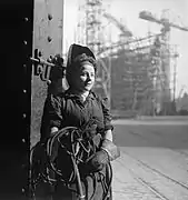 Une soudeuse sur un chantier naval, au Royaume-Uni, en 1943. En arrière-plan : un navire en construction.