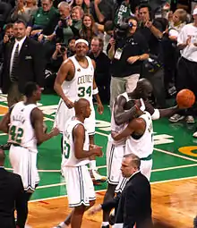 Rondo et Garnett dans les bras l'un de l'autre, trois autres joueurs des Celtics s'approchant.