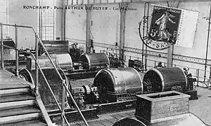 Photo noir et blanc montrant une grande salle avec les générateurs électriques.