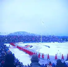 Le drapeau olympique levé dans un stade en plein air.