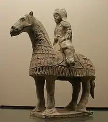Photo d'une statue de terre cuite montrant un cheval et son cavalier, tous les deux vêtus d'une armure