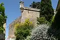 Perspective sur les remparts et, derrière, le mur (percé de meurtrières) et l'entrée de l'église (2017)