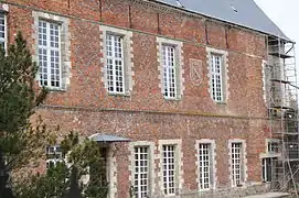 Bâtiment sur cour avec blason et inscriptions.