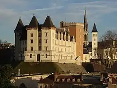 Photographie en couleurs d'un château au milieu d'une ville.