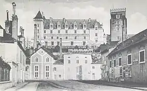 Photographie en noir et blanc d'usines avec de hautes cheminées devant un château.