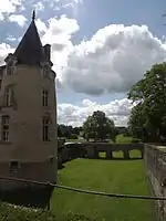 Tour droite du château et vue des douves vides et d'une partie du golf