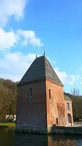 La tour carrée, les douves et, à l'arrière plan au pied de la colline, l'escalier à double révolution de l'ancien château des ducs d'Elbeuf.