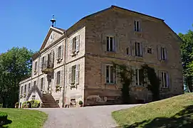 Vue dégagé du bâtiment dont les murs sont en pierre de taille nues.