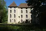 Château de Lusigny-sur-Ouche vue de face, légèrement caché par les arbres