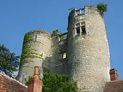 vue en contre-plongée de deux tours cylindriques reliées par une muraille pourvue de fenêtres.