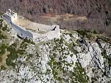 Photographie aérienne contemporaine de ruines d'un château bâti sur une éminence.