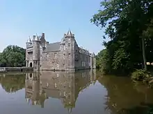 Château fort médiéval qui se reflète dans les eaux d'un étang