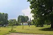 Vue dans le parc du château Pirmez avec les flèches de l'église.