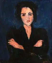 Sur fond bleu nuit, portrait à mi-corps d'une femme brune en robe noire, bras croisés.