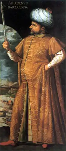 tableau : portrait en pied de profil d'un homme barbu à turban blanc et manteau orange