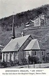 Photo en noir et blanc. La chapelle anglaise de Davos et derrirèe, sur une colline, un grand chalet