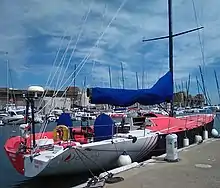 Vu de trois quarts arrière, bateau rouge et blanc, amarré au ponton.