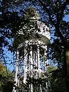 Château d'eau métallique vu à travers les arbres.