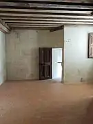 Pièce claire aux murs blancs et des poutres au plafond, à l'entresol du château de Chambord.
