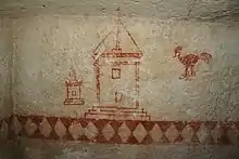 Vue de détail d'une pièce souterraine munie de fresques peintes en rouge