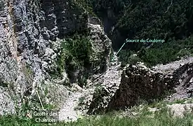 Vue d'ensemble de la grotte des Chamois, à gauche sur la vire, et de la source du Coulomp au pied de l'éboulis.