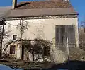 Une maison traditionnelle avec son montage ; toit à tuiles en écailles et ardoises, sur génoise