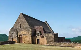 Photographie d'une chapelle médiévale. Le paysage est légèrement visible derrière.