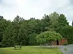 L'espace vert avec des tables de pique-nique et un chalet où sont exposées des photos et des articles sur les apparitions de la Vierge Marie, l'histoire de la chapelle et de l'association.