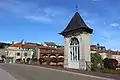 Vue d'une petite chapelle avec une porte vitrée située sur un pont.