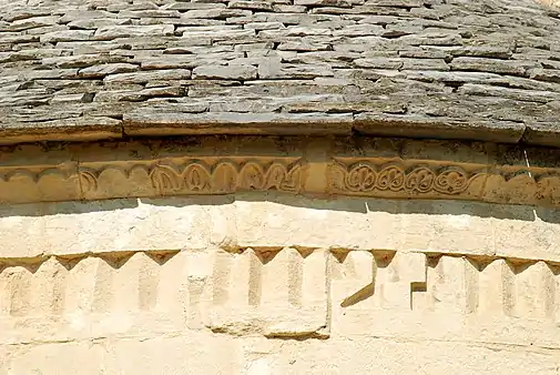 Corniche en biseaudécorée de grains d'orge et de palmettes.