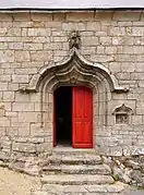 Vue d’une porte rouge vif d’un bâtiment gothique.