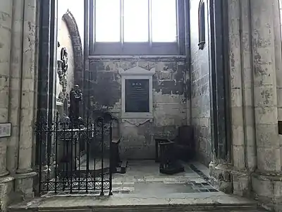 Chapelle éclairée par une verrière avec, sur le mur de gauche, une statue de Saint-Antoine posée sur un autel, sur le mur en face de l’objectif, une plaque de marbre noir, et, sur le mur de droite, une niche vide.