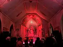 Une chapelle illuminée d'un éclairage de scène aux teintes rouges.