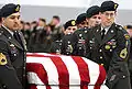 Une équipe du 1er groupe de forces spéciales portant le cercueil drapé du sergent de première classe Nathan R. Chapman le 8 janvier 2002 à l'aéroport international de Seattle-Tacoma.