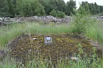 Un puits remblayé et sécurisé au charbonnage de Werister (on distingue bien la borne indicatrice au milieu de la dalle en béton).