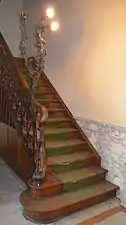 Départ d'escalier en bois et fer forgé.
