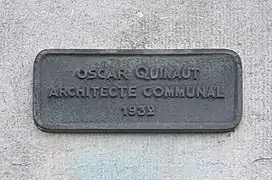 plaque métallique portant les inscriptions en relief : Oscar Quinaut architecte communal 1932