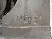 Signature "Jul. Lagae" suivi d'un double obèle tracée dans le bronze.