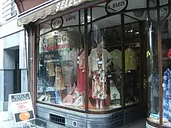 Vitrine située à la rue Neuve, dessinée par Hector Tonet. Enlevé en 2017 elle retrouve sa place en 2019 en façade du nouvel immeuble construit à cet endroit.