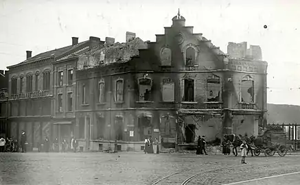 Photo ancienne en noir et blanc d'une rue avec des bâtiments ruinés.