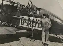 Photographie noir et blanc des trois hommes devant l'avion.