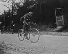 Photographie en noir et blanc montrant un cycliste en course.